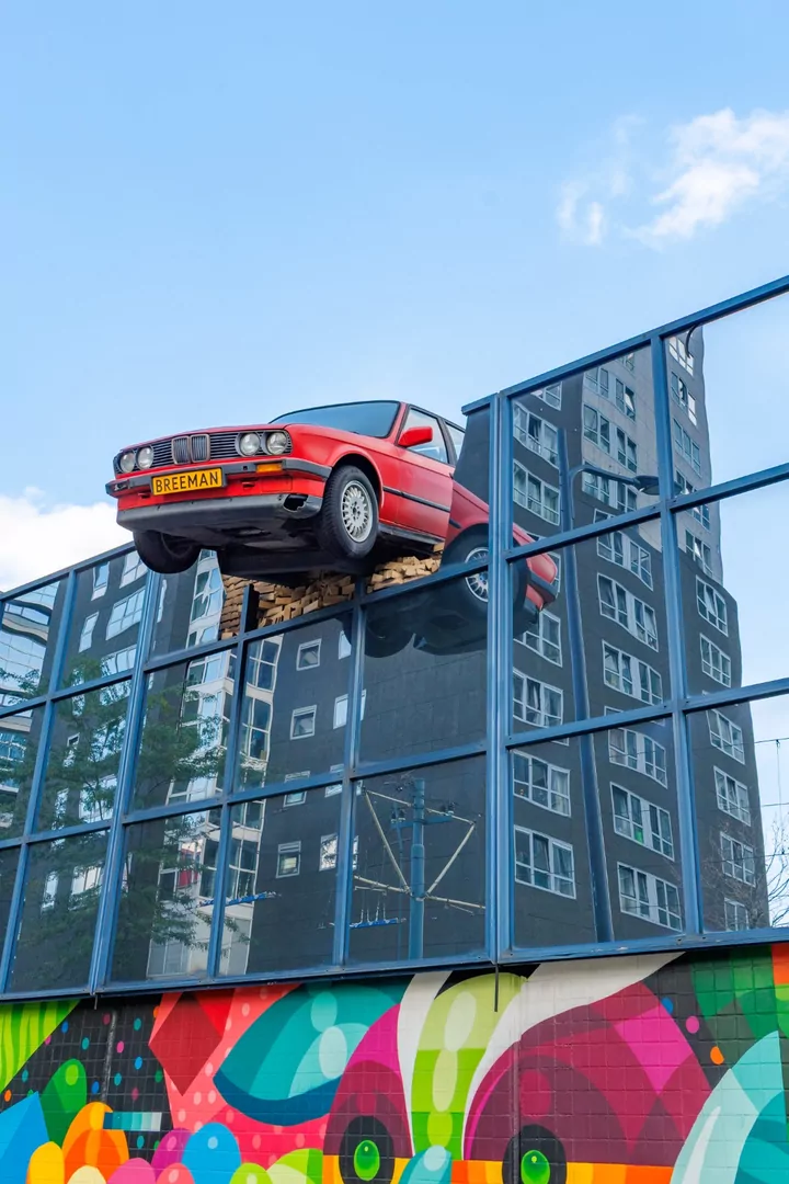 Er hangt sinds 1989 een rode BMW door de muur van de parkeergarage als kunstobject.