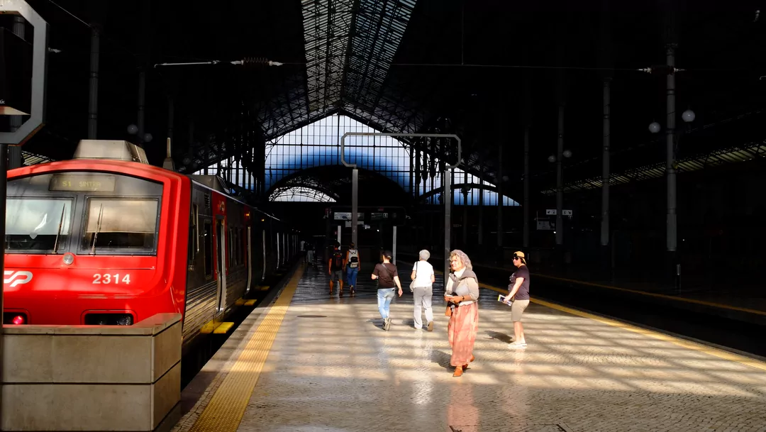 Het station in Lissabon met een vuurrode stilstaande trein.